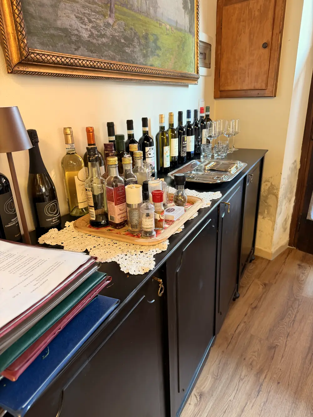 Le bottiglie di vino in fila sulla credenza della sala.